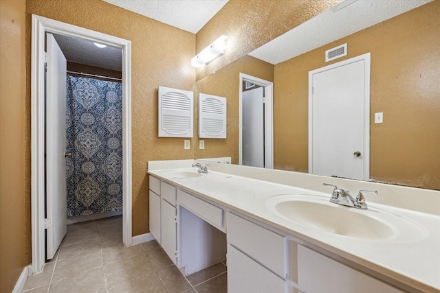 3600 Jeanetta St Unit 1902, Houston, TX 77063 - full bath featuring a textured wall, double vanity, tile patterned flooring, and a textured ceiling