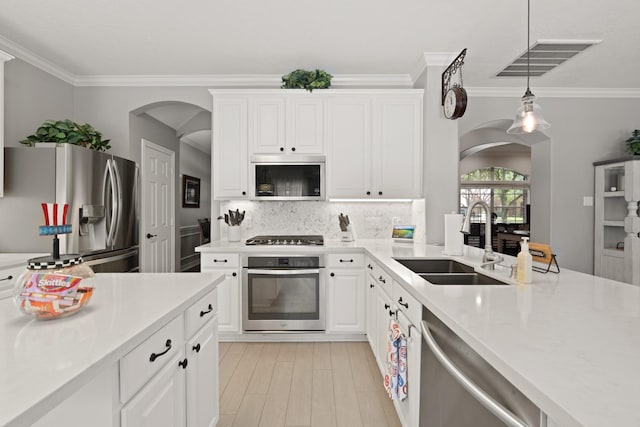 16403 Bogan Flats Ct, Houston, TX 77095 - kitchen featuring appliances with stainless steel finishes, arched walkways, crown molding, and light countertops