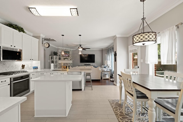 16403 Bogan Flats Ct, Houston, TX 77095 - kitchen featuring stainless steel appliances, crown molding, light countertops, a ceiling fan, and open floor plan