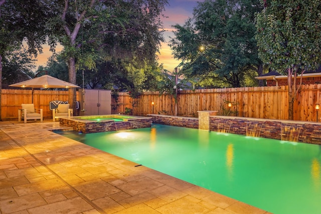 16403 Bogan Flats Ct, Houston, TX 77095 - pool at dusk with a patio, a fenced backyard, a pool with connected hot tub, and a storage shed