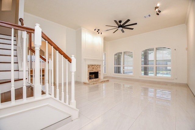 9302 Stone Porch Ln, Houston, TX 77064 - unfurnished living room with ceiling fan, tile patterned flooring, stairs, a tile fireplace, and crown molding