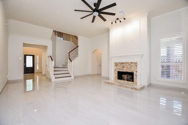 9302 Stone Porch Ln, Houston, TX 77064 - unfurnished living room featuring arched walkways, ceiling fan, stairway, ornamental molding, and a tile fireplace