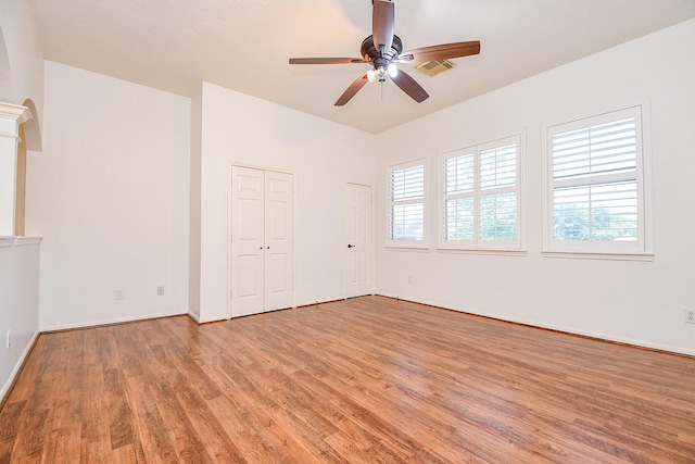 9302 Stone Porch Ln, Houston, TX 77064 - empty room with light wood-style flooring, a ceiling fan, and ornate columns