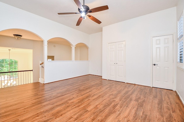 9302 Stone Porch Ln, Houston, TX 77064 - empty room featuring a ceiling fan, wood finished floors, and arched walkways