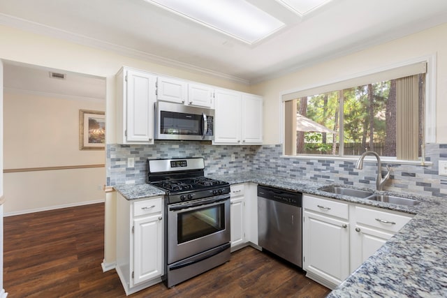 34 Sweetdream Pl, The Woodlands, TX 77381 - kitchen with appliances with stainless steel finishes, crown molding, light stone countertops, dark wood-type flooring, and decorative backsplash