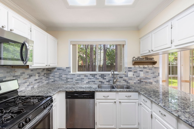 34 Sweetdream Pl, The Woodlands, TX 77381 - kitchen with appliances with stainless steel finishes, white cabinets, plenty of natural light, decorative backsplash, and crown molding