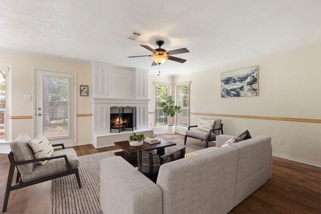34 Sweetdream Pl, The Woodlands, TX 77381 - living room with healthy amount of natural light, a fireplace, dark wood-style flooring, a ceiling fan, and crown molding