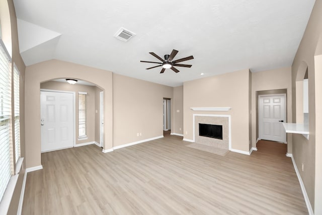 7407 Rustic Chase Dr, Richmond, TX 77407 - unfurnished living room with arched walkways, ceiling fan, light wood-type flooring, and healthy amount of natural light