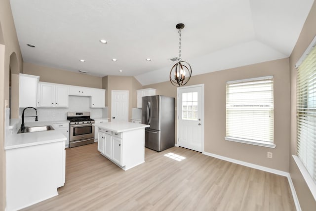 7407 Rustic Chase Dr, Richmond, TX 77407 - kitchen featuring stainless steel appliances, light wood finished floors, light countertops, a kitchen island, and lofted ceiling