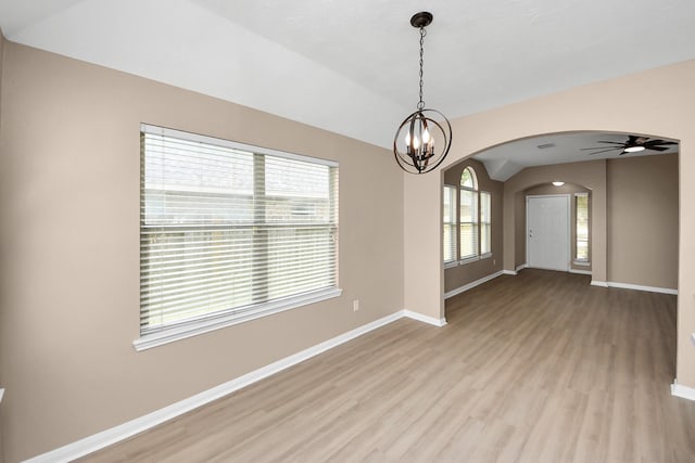 7407 Rustic Chase Dr, Richmond, TX 77407 - empty room featuring arched walkways, light wood-style floors, lofted ceiling, a chandelier, and a ceiling fan