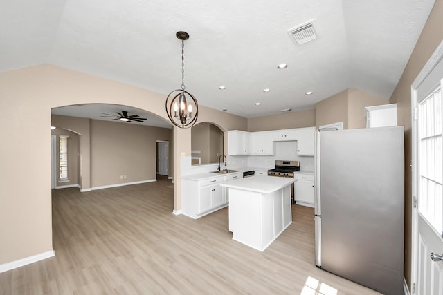 7407 Rustic Chase Dr, Richmond, TX 77407 - kitchen featuring stainless steel appliances, arched walkways, vaulted ceiling, a ceiling fan, and light countertops