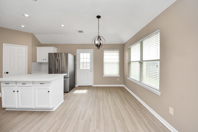 7407 Rustic Chase Dr, Richmond, TX 77407 - kitchen with freestanding refrigerator, white cabinetry, light wood finished floors, a chandelier, and light countertops