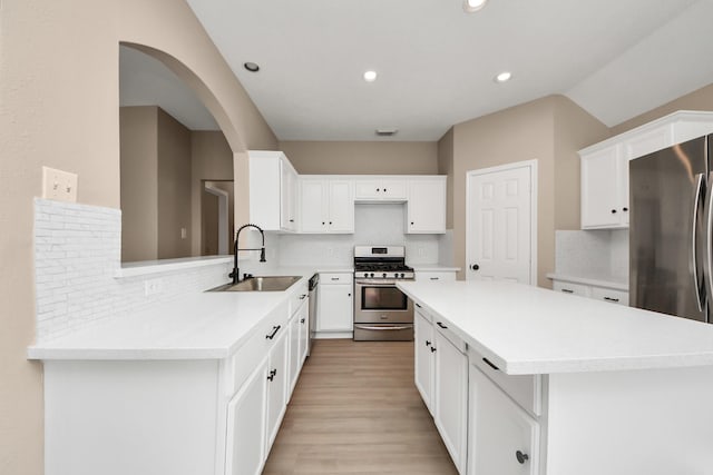 7407 Rustic Chase Dr, Richmond, TX 77407 - kitchen featuring appliances with stainless steel finishes, decorative backsplash, recessed lighting, a center island, and light countertops