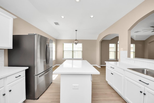 7407 Rustic Chase Dr, Richmond, TX 77407 - kitchen featuring freestanding refrigerator, a kitchen island, lofted ceiling, light wood finished floors, and light countertops