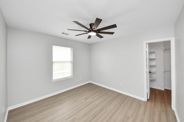 7407 Rustic Chase Dr, Richmond, TX 77407 - unfurnished bedroom with wood finished floors, a spacious closet, a closet, and ceiling fan