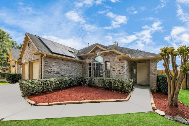 7407 Rustic Chase Dr, Richmond, TX 77407 - view of front facade featuring brick siding, roof mounted solar panels, driveway, an attached garage, and roof with shingles