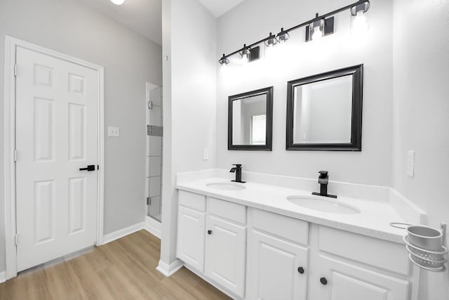 7407 Rustic Chase Dr, Richmond, TX 77407 - bathroom with a stall shower, double vanity, and wood finished floors