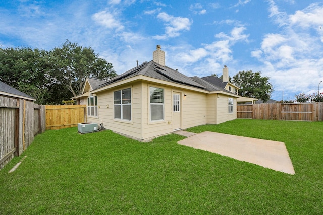 7407 Rustic Chase Dr, Richmond, TX 77407 - rear view of property with solar panels, a fenced backyard, a patio area, and a chimney