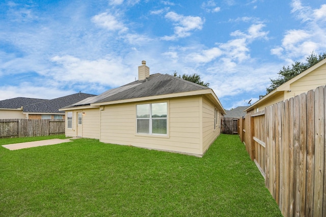 7407 Rustic Chase Dr, Richmond, TX 77407 - rear view of house with a fenced backyard, a chimney, a patio area, and a shingled roof