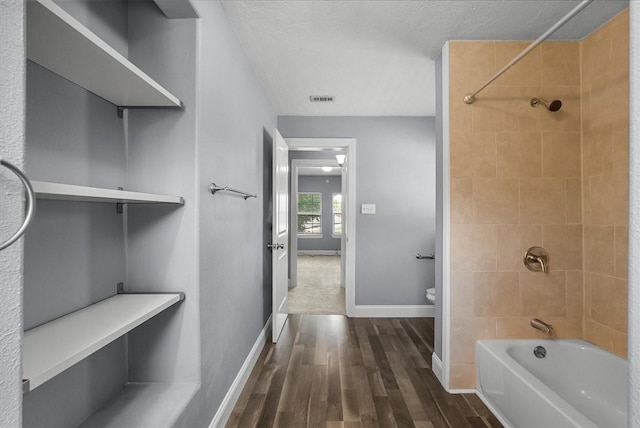 3217 Michigan St, Baytown, TX 77520 - full bath featuring bathing tub / shower combination, wood finished floors, and a textured ceiling