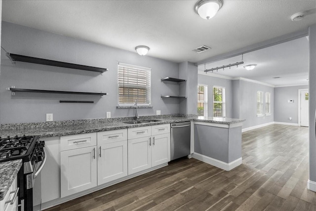 3217 Michigan St, Baytown, TX 77520 - kitchen with open shelves, appliances with stainless steel finishes, a peninsula, dark wood finished floors, and ornamental molding