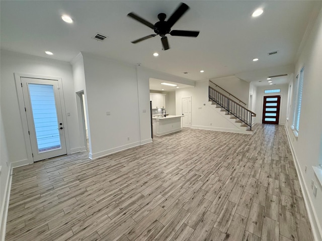 6635 Tc Jester Blvd Unit A, Houston, TX 77007 - unfurnished living room with light wood-type flooring, stairway, ceiling fan, and recessed lighting