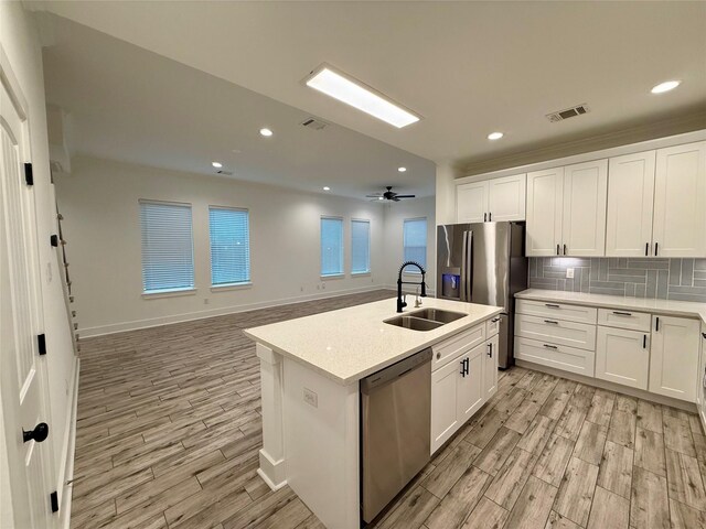 6635 Tc Jester Blvd Unit A, Houston, TX 77007 - kitchen with stainless steel appliances, light wood finished floors, light countertops, white cabinets, and recessed lighting