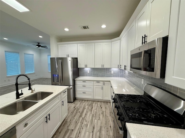 6635 Tc Jester Blvd Unit A, Houston, TX 77007 - kitchen featuring stainless steel appliances, light wood-type flooring, white cabinetry, decorative backsplash, and recessed lighting