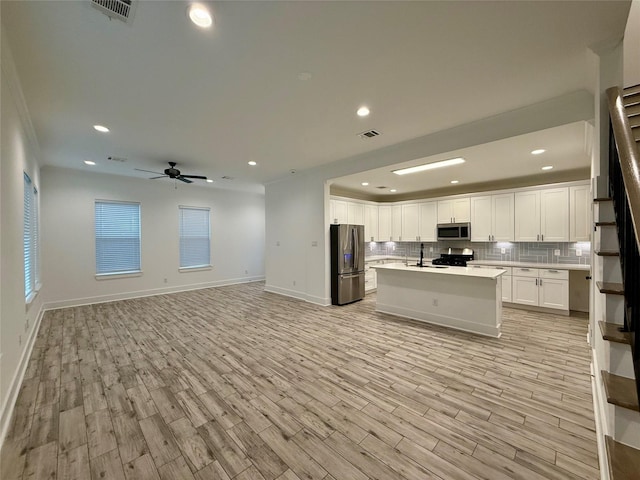 6635 Tc Jester Blvd Unit A, Houston, TX 77007 - kitchen featuring appliances with stainless steel finishes, decorative backsplash, open floor plan, light wood finished floors, and recessed lighting