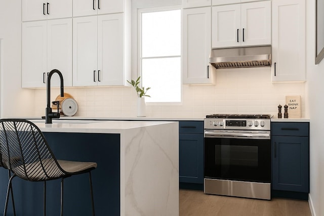 811 Thornton Rd Unit B, Houston, TX 77018 - kitchen featuring gas range, decorative backsplash, light wood-style flooring, wall chimney exhaust hood, and white cabinets