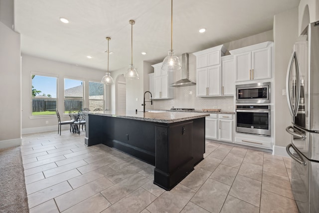 16715 Bark Cabin Dr, Humble, TX 77346 - kitchen featuring appliances with stainless steel finishes, wall chimney exhaust hood, backsplash, recessed lighting, and a kitchen island with sink