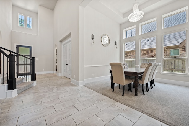 16715 Bark Cabin Dr, Humble, TX 77346 - dining space featuring a towering ceiling, a chandelier, stairway, plenty of natural light, and carpet floors