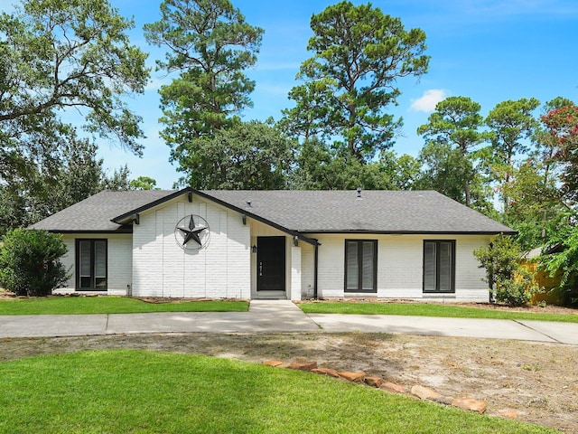 19518 Barwick Dr, Spring, TX 77373 - view of front of house with a front yard, a shingled roof, brick siding, and french doors