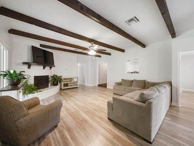 19518 Barwick Dr, Spring, TX 77373 - living room featuring beam ceiling, a ceiling fan, a fireplace, and light wood-style floors