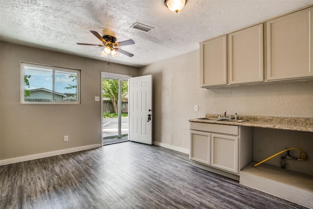 4820 Oak Ave Unit 16, Pasadena, TX 77503 - kitchen featuring dark wood-type flooring, ceiling fan, a textured ceiling, light countertops, and cream cabinetry