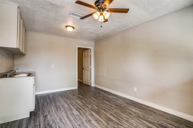 4820 Oak Ave Unit 16, Pasadena, TX 77503 - unfurnished living room with dark wood-style flooring, ceiling fan, and a textured ceiling