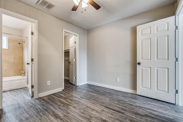 4820 Oak Ave Unit 16, Pasadena, TX 77503 - unfurnished bedroom featuring dark wood-type flooring, a spacious closet, connected bathroom, a closet, and a textured ceiling