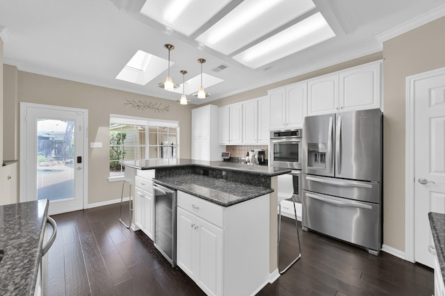 35 S Floral Leaf Cir, The Woodlands, TX 77381 - kitchen with appliances with stainless steel finishes, a skylight, dark wood-style flooring, wine cooler, and white cabinetry