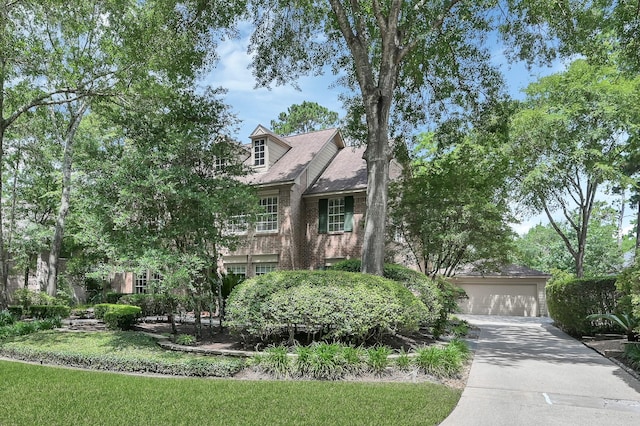 35 S Floral Leaf Cir, The Woodlands, TX 77381 - view of front of house with a garage, brick siding, and driveway