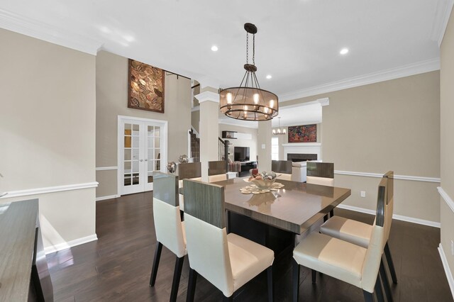 35 S Floral Leaf Cir, The Woodlands, TX 77381 - dining space with dark wood finished floors, ornamental molding, a chandelier, a fireplace, and french doors