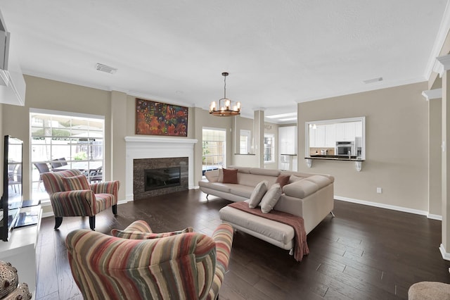 35 S Floral Leaf Cir, The Woodlands, TX 77381 - living room with plenty of natural light, a glass covered fireplace, a chandelier, dark wood-style flooring, and ornamental molding