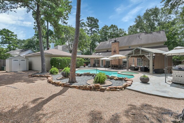 35 S Floral Leaf Cir, The Woodlands, TX 77381 - view of pool with a patio, a shed, a pool with connected hot tub, and an outdoor hangout area