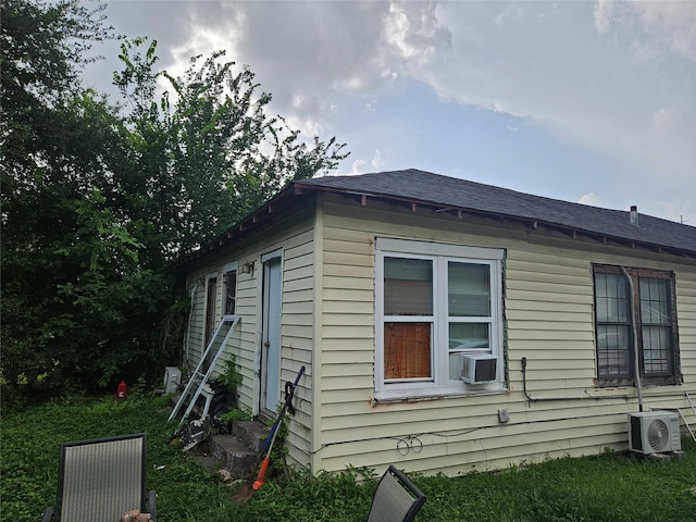 6504 Ave J, Houston, TX 77011 - view of side of property with entry steps, a shingled roof, and cooling unit