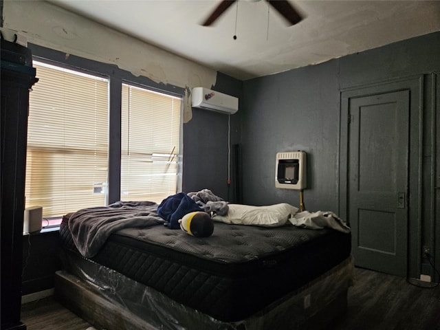 6504 Ave J, Houston, TX 77011 - bedroom featuring an AC wall unit, heating unit, dark wood finished floors, and ceiling fan