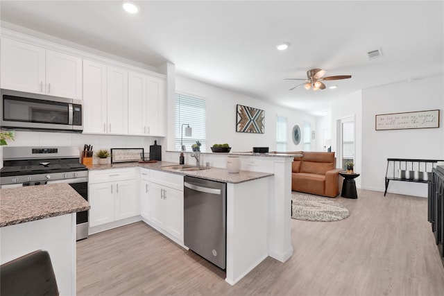 23823 Escardilla Ln, Hockley, TX 77447 - kitchen featuring appliances with stainless steel finishes, light wood-style floors, white cabinetry, and recessed lighting