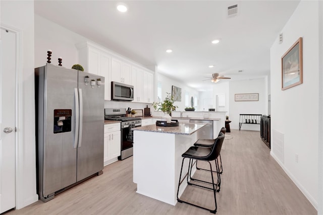23823 Escardilla Ln, Hockley, TX 77447 - kitchen featuring appliances with stainless steel finishes, a peninsula, white cabinets, ceiling fan, and recessed lighting