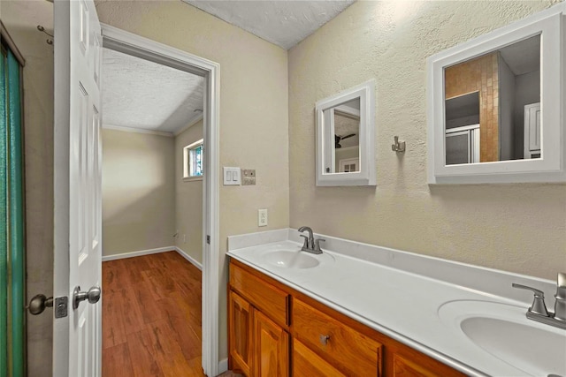 925 Royal Oak Dr, Dickinson, TX 77539 - bathroom with double vanity, a textured ceiling, wood finished floors, and a textured wall