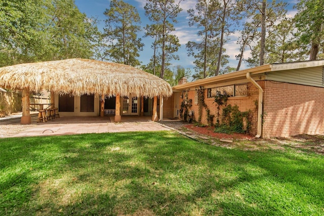 925 Royal Oak Dr, Dickinson, TX 77539 - back of house featuring a yard, a patio, and brick siding