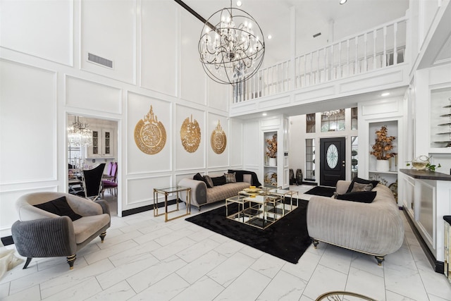 14907 Alderwick Dr, Sugar Land, TX 77498 - living area featuring a decorative wall, a chandelier, light marble finish flooring, and a high ceiling