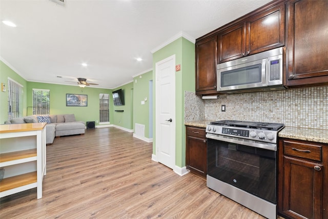 3 Whistlers Walk Pl, The Woodlands, TX 77381 - kitchen with appliances with stainless steel finishes, ornamental molding, light wood-type flooring, tasteful backsplash, and dark brown cabinetry
